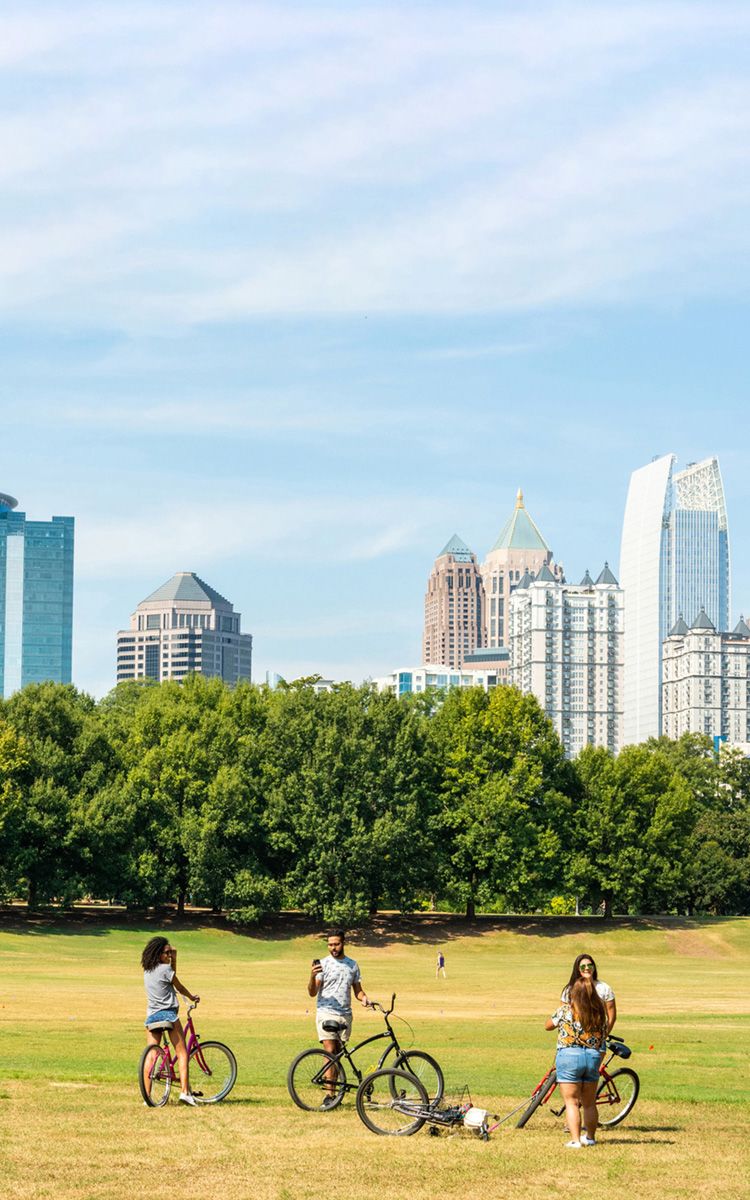 People stand with bikes in a field