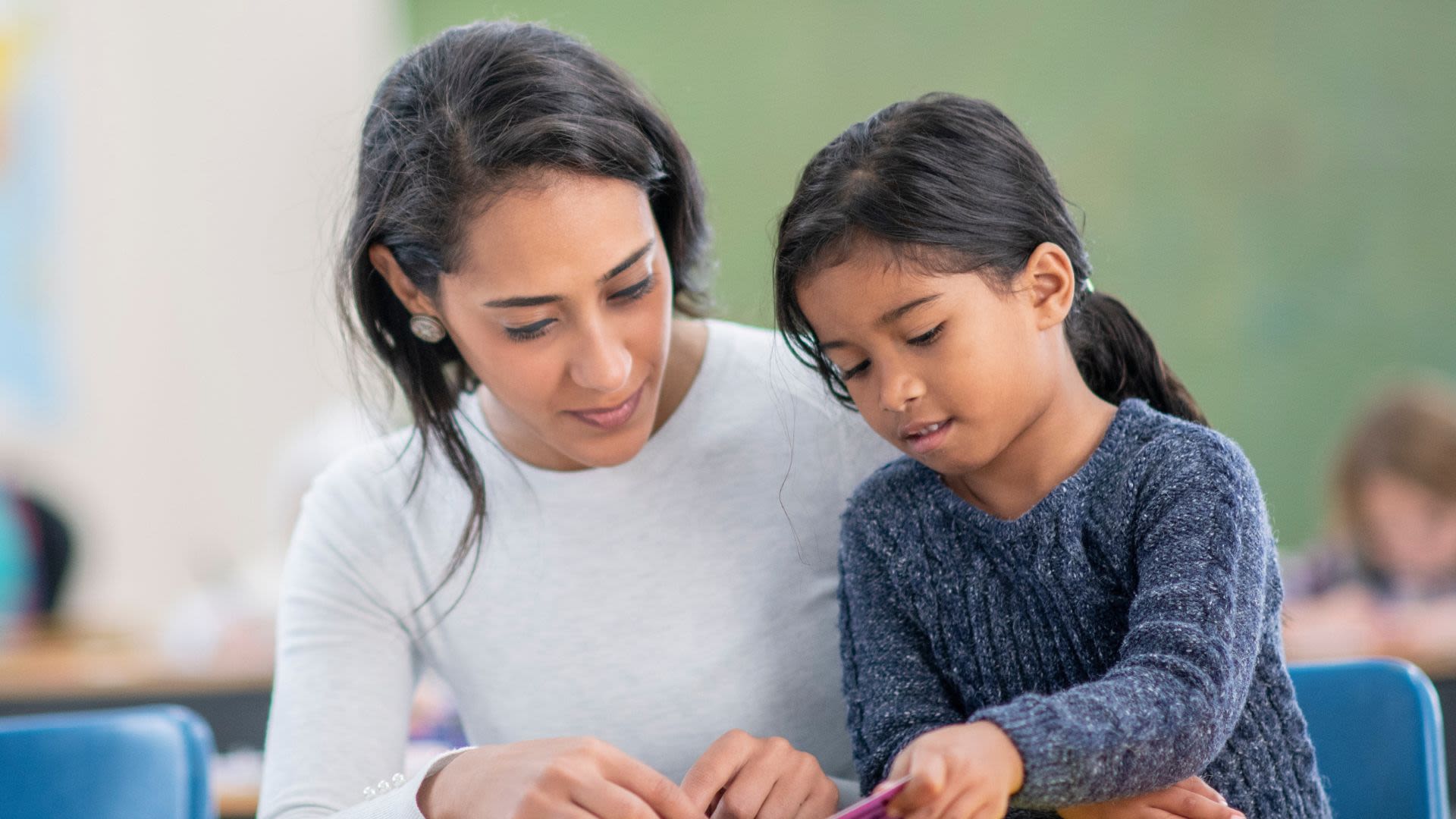 A UGA Extension agent presenting to a crowd of children in an outdoor setting.