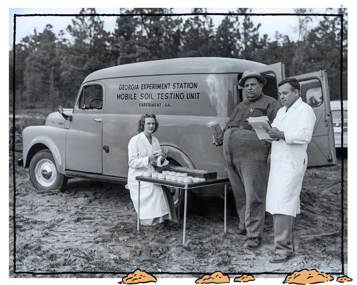 1950s era black and white photo of a soil testing truck in the field. A woman in a lab coat sits at a folding table, preparing samples. A farmer holds a soil sample bag and a man in a lab coat examines papers.