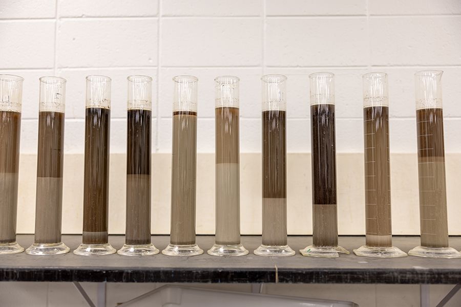 Ten large, cylindrical tubes contain liquid and striations of silt, sand and clay