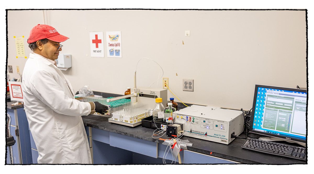 A man looks at a tray of vials being processed by a countertop machine