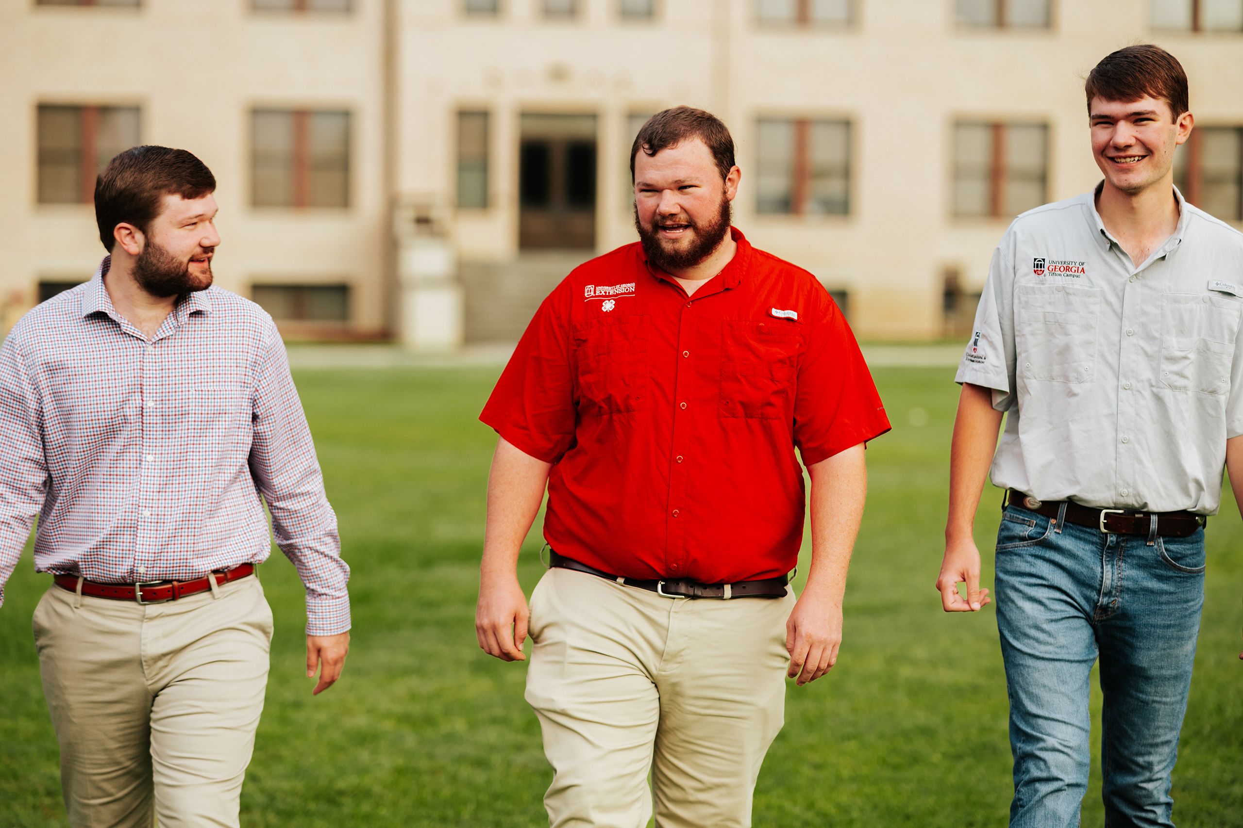 Three men from the same family talk and smile together on the UGA Tifton campus. 