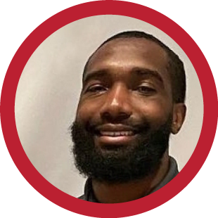 A smiling Black man with a beard.