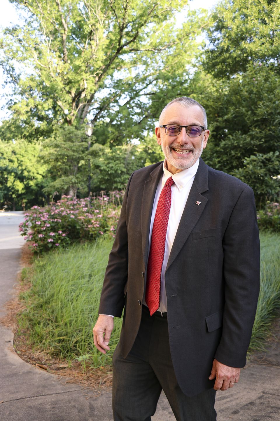 CAES Dean and Director, Nick T. Place, smiles for the camera in a black suit and red tie.