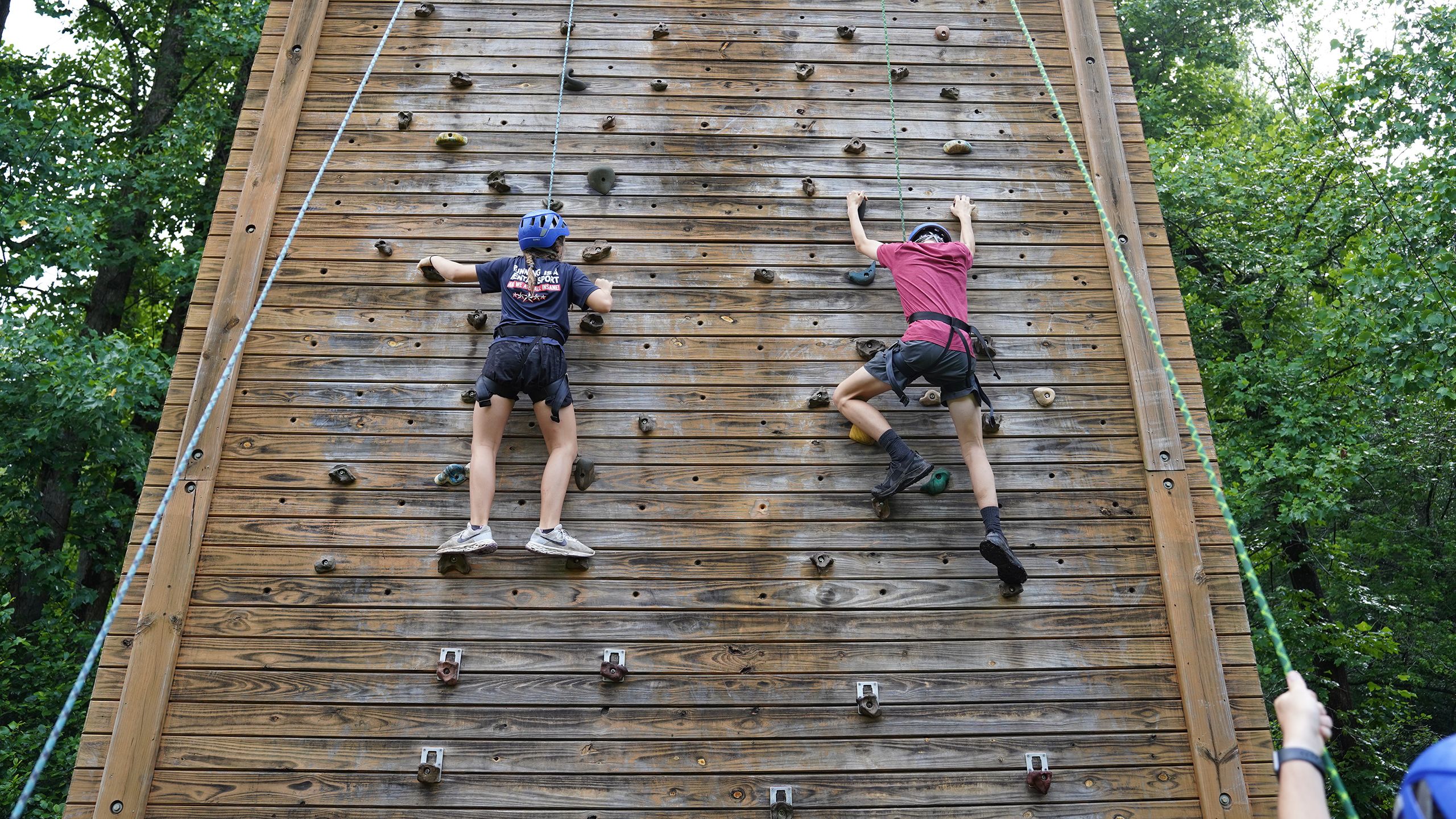 Two children climbing a rock wall