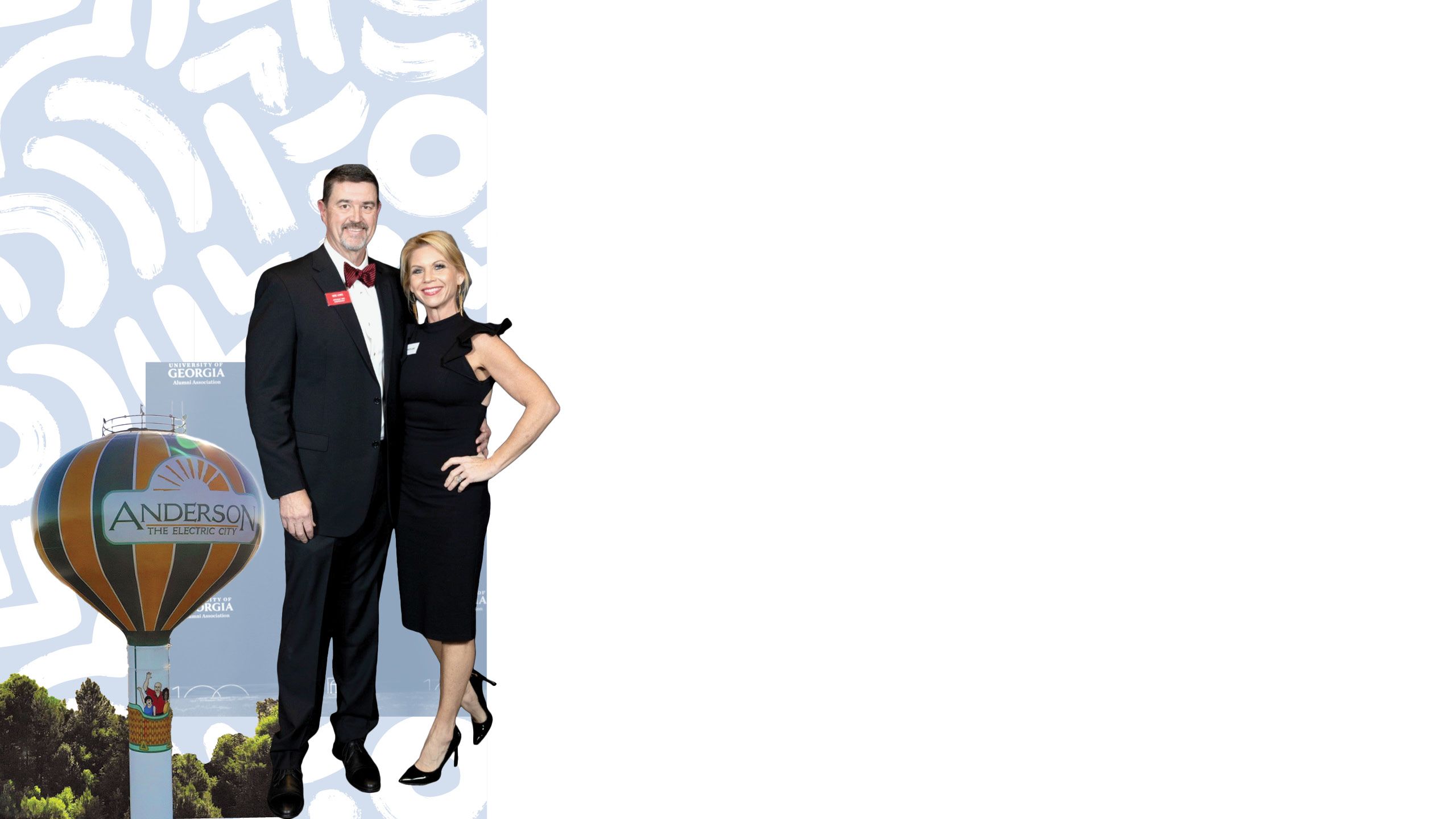 Mike Lewis stands with his wife, both in formal attire, in front of a Bulldog 100 sign. There is a photo of a large yellow and black-striped water tower that says "Anderson, the Electric City" behind them.