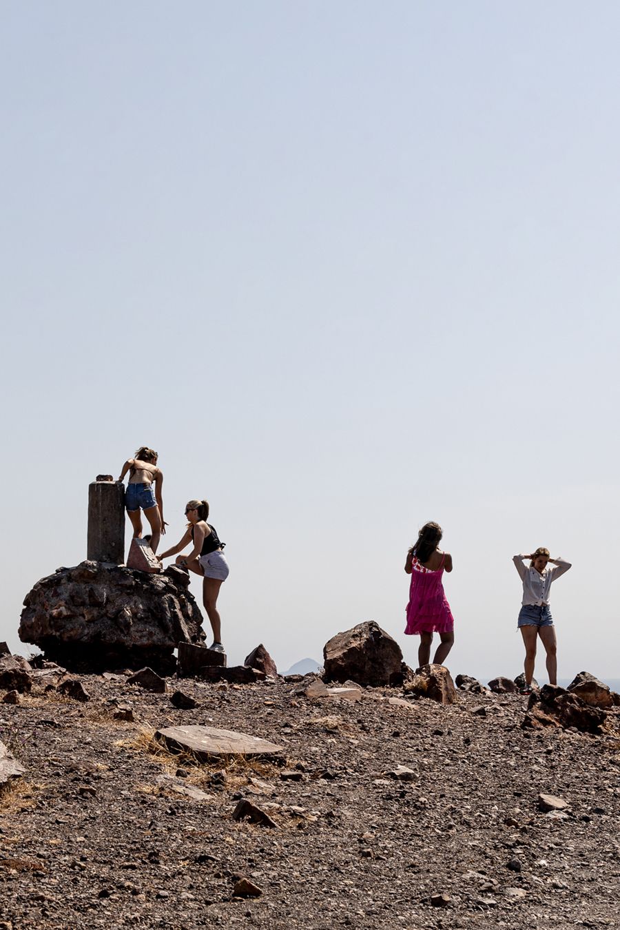 Students stand on the rocky ridge of a volcanic crater