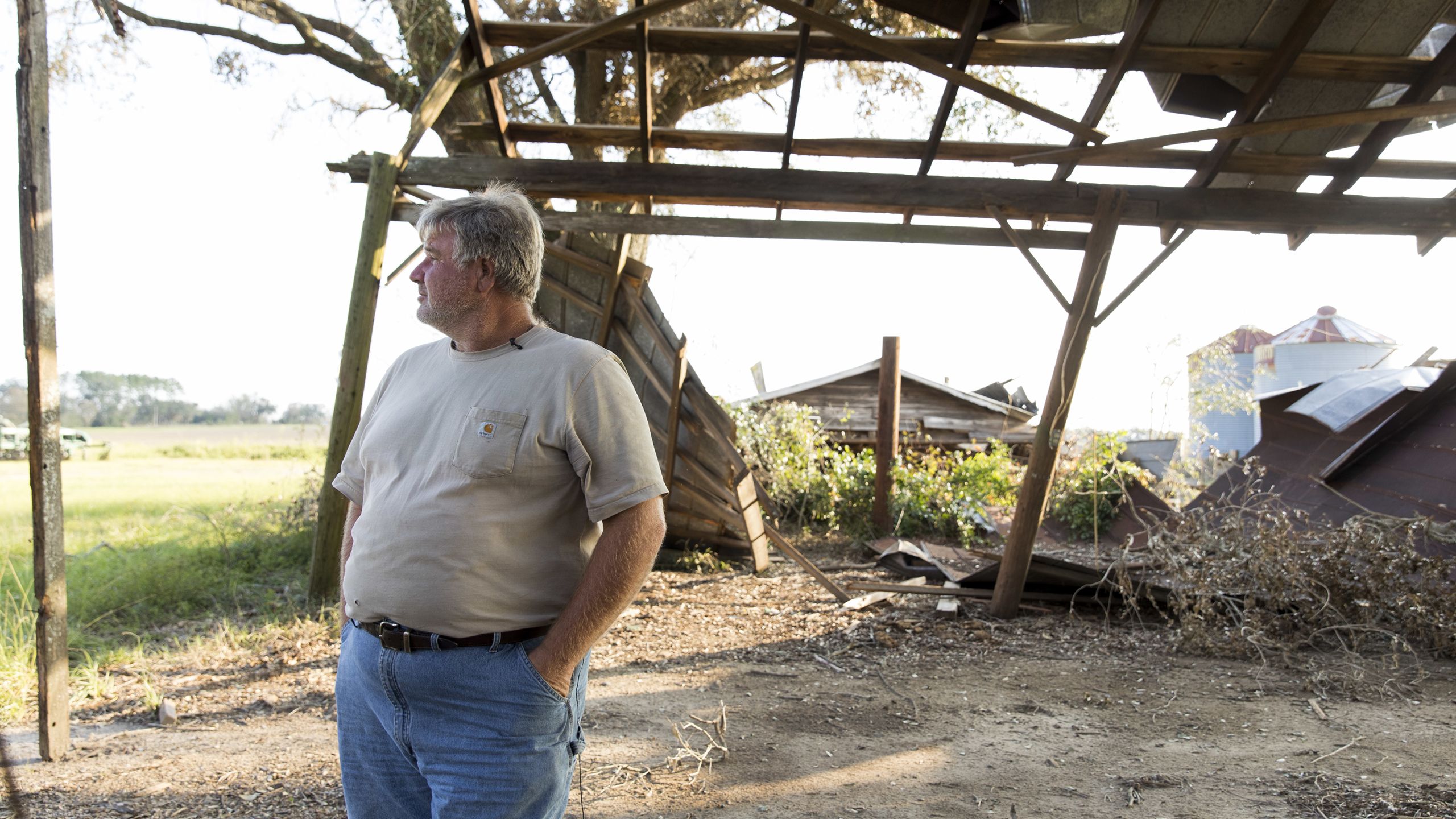 Jeff Barber stands under the skeleton of a damaged wooden structure