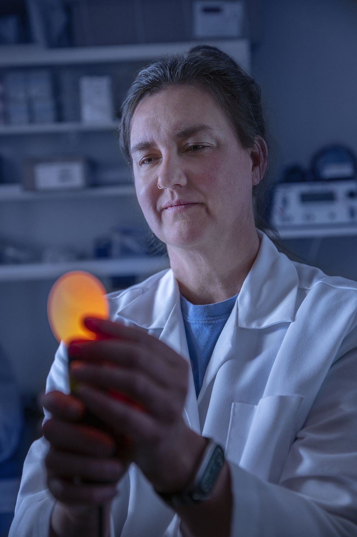 A candled chicken egg glows in the hands of poultry science Assistant Professor Laura Ellestad