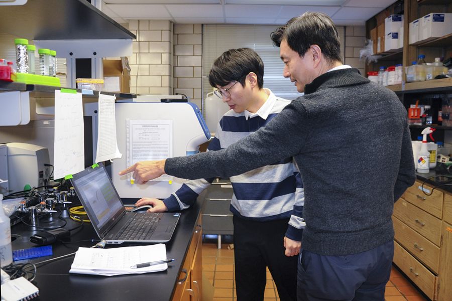 Jihwan Lee and woo Kyun Kim stand in a lab looking at a computer