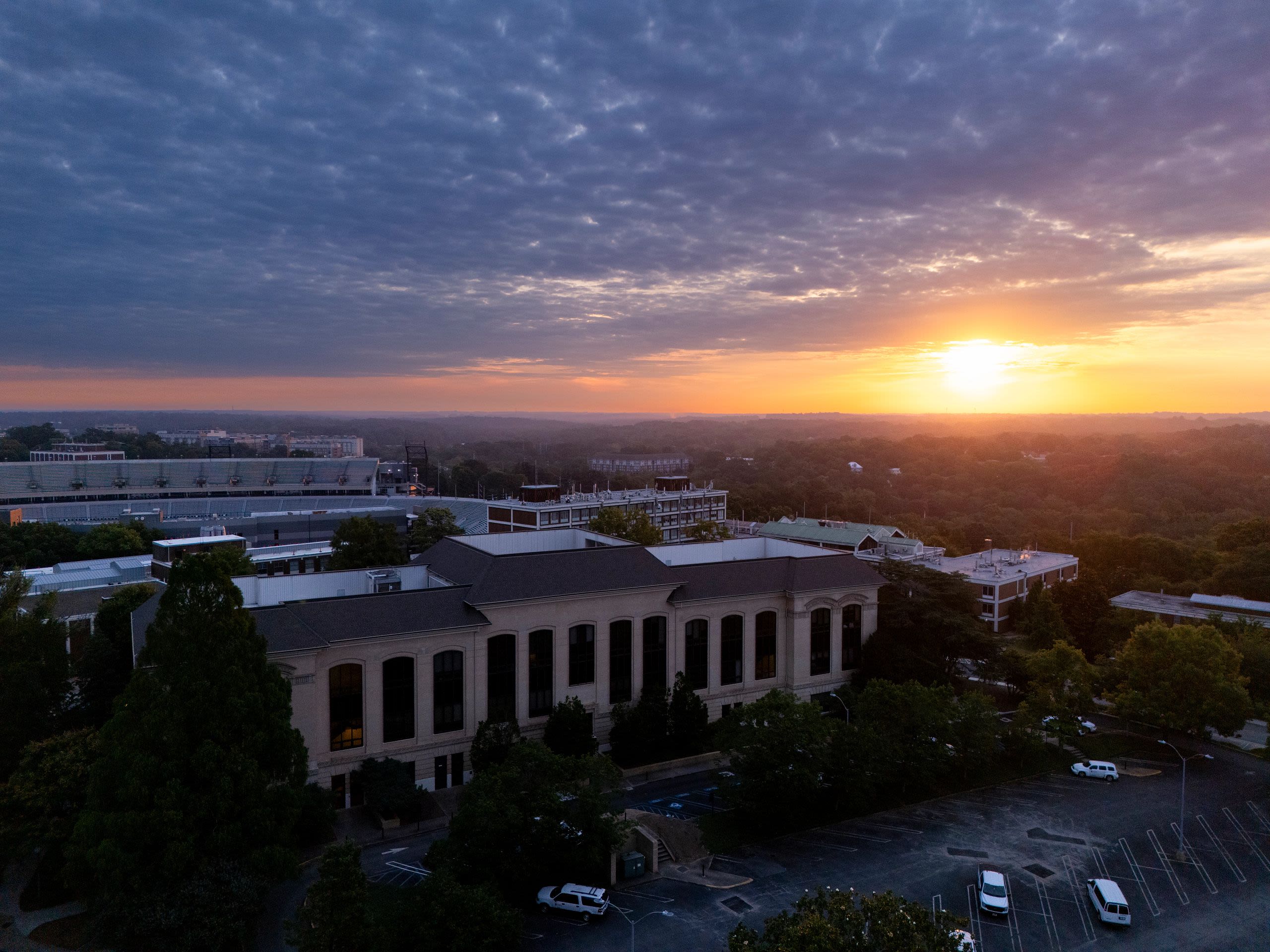 A sun setting over a college campus