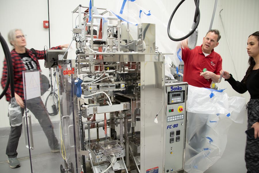 Gratzek and Moore display a large machine for packaging powdered food