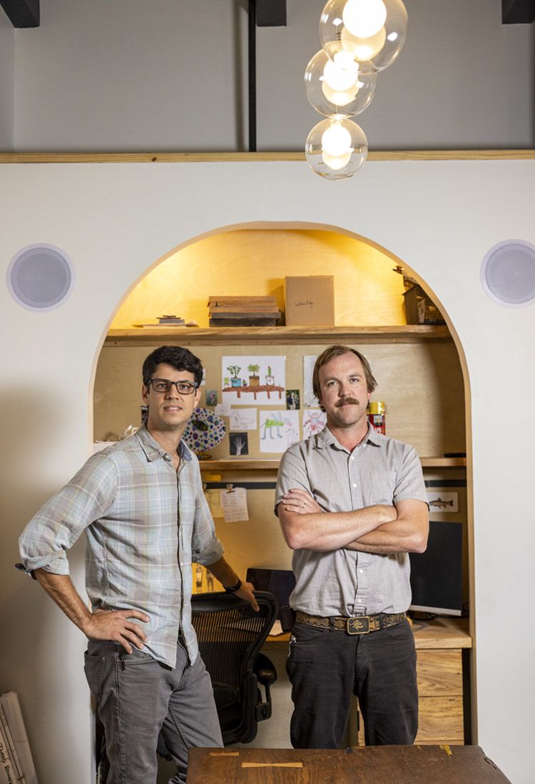 Andrew Malec and Zack Brendel stand in an arched doorway in their studio.